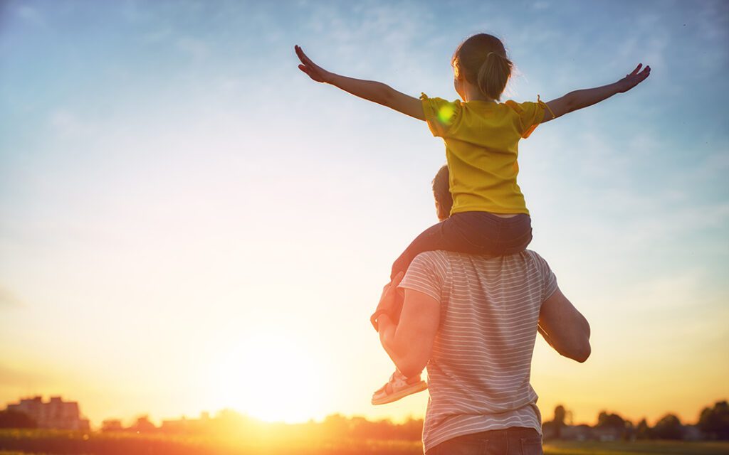 Padre dejando que la niña vea el Sol.